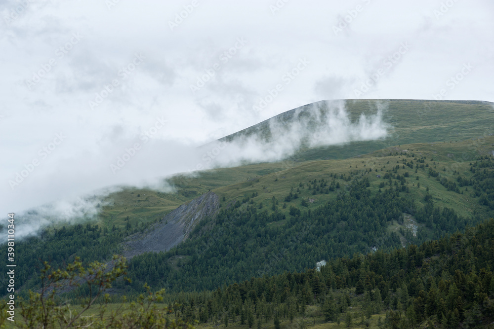 Altai mountains shrouded in white clouds, it looks quite gloomy Altai mountains shrouded in white clouds, it looks quite gloomy