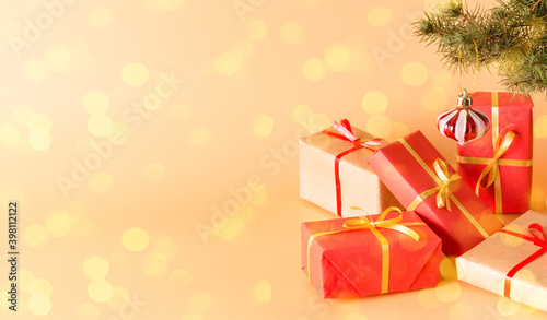 Fabulous gifts in beautiful multi-colored boxes with gold ribbons under a Christmas tree decorated with glass toys. Holiday. New year and Christmas Copy space © garmashevanatali