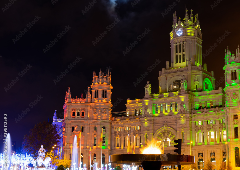 Madrid, Spain, November 28, 2020: The flame dedicated to the people killed by the covid19 pandemic. Illuminated by green and yellow lights for the Christmas celebrations, the city council of Madrid.