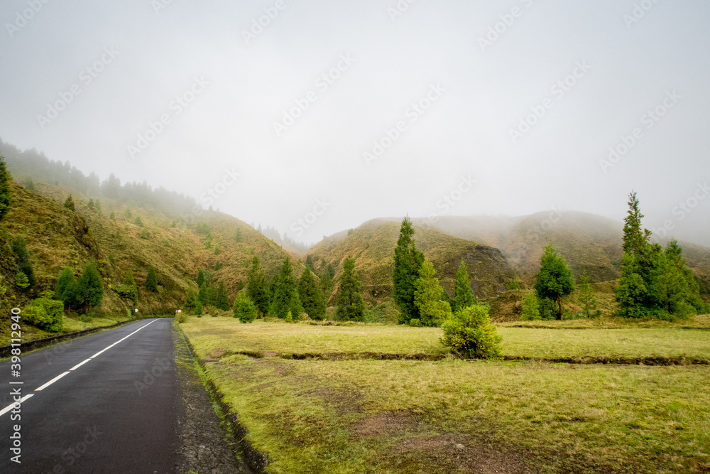 Fototapeta premium Foggy landscape in the Azores amidst the volcano mountains on the road