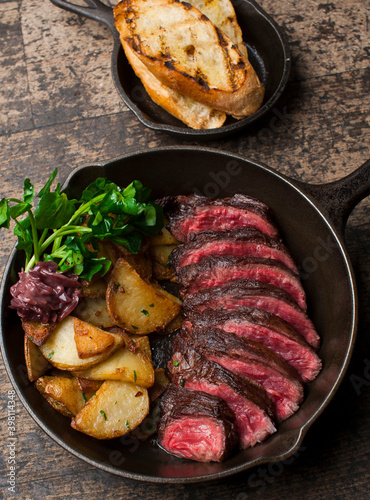 Steak and potatoes. Grade A grass fed angus beef steaks. Tenderloin, filet mignon, New York strip, bone in rib-eye grilled medium rare on outdoor wood-fired grill. Classic American steakhouse entree.