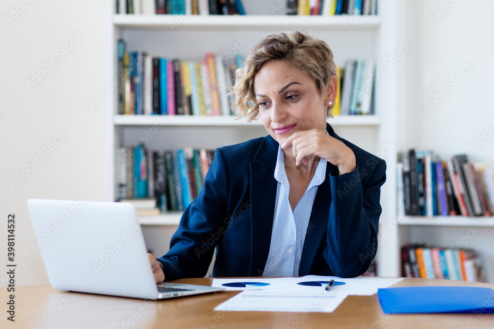 Mature adult businesswoman watching movie at computer Mature adult businesswoman watching movie at computer