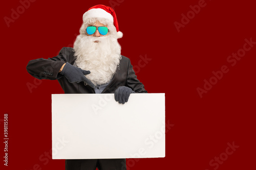 santa claus in costume shows white poster