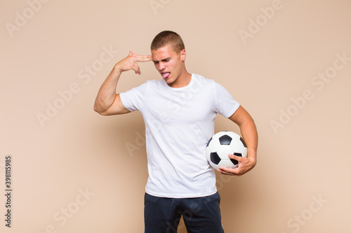 Cuadro en lienzo young blonde man looking unhappy and stressed, suicide gesture making gun sign w