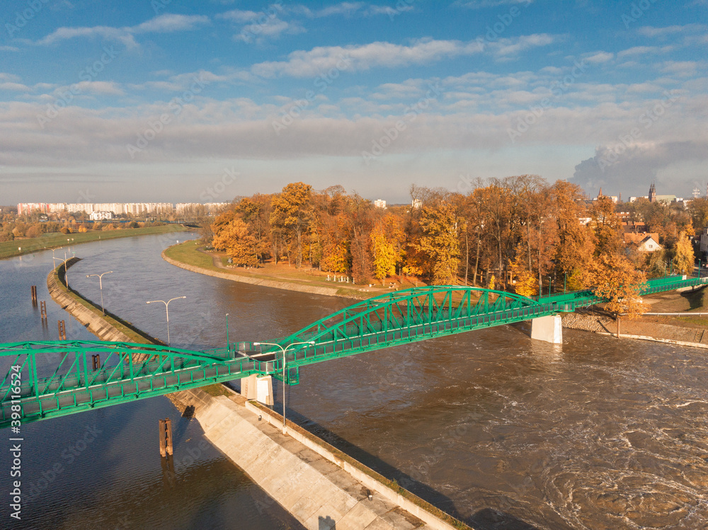 Fototapeta premium Green bridge to the Bolko island in Opole in autumn scenery