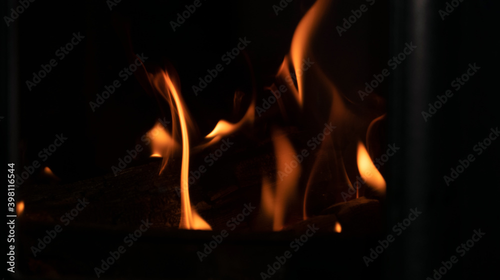fire in the fireplace close-up on a dark, background image