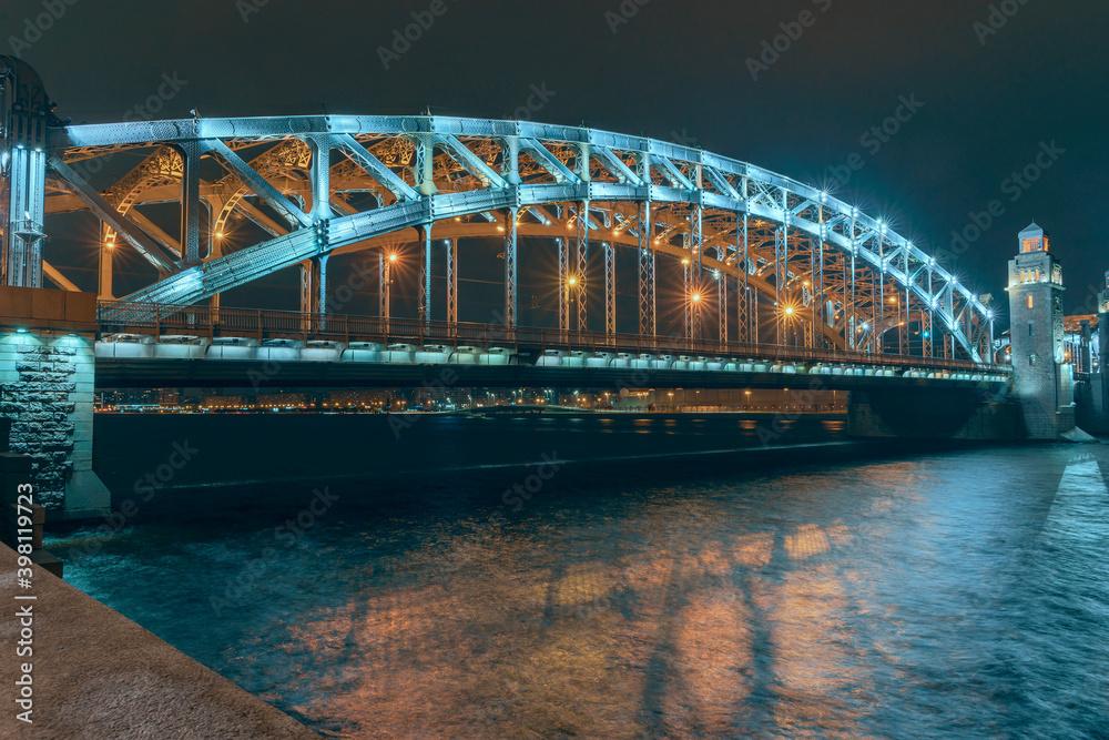 Naklejka premium the beautiful metal bridge of Peter the Great across the Neva River in St. Petersburg against the night sky