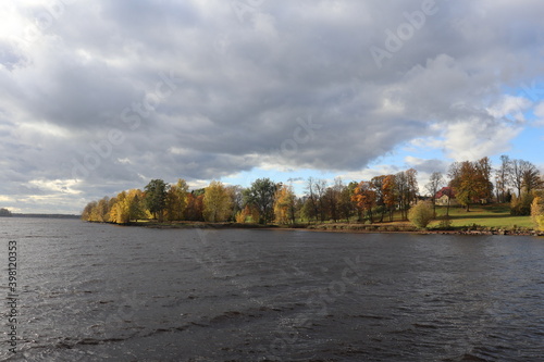 Panorama across the river to the opposite bank with yellowed autumn trees