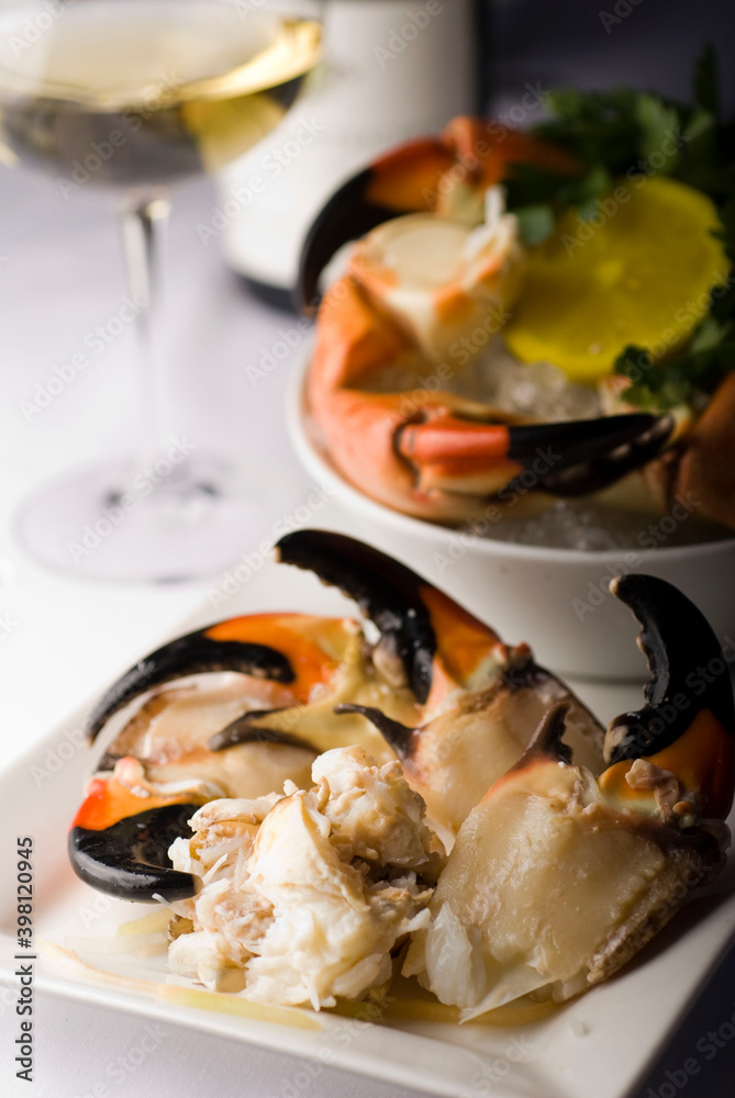 Stone crab claws. Colossal Crab claws served with lemons, spicy rémoulade sauce on top of a mixed green salad. Classic American restaurant or steakhouse appetizer or entree.