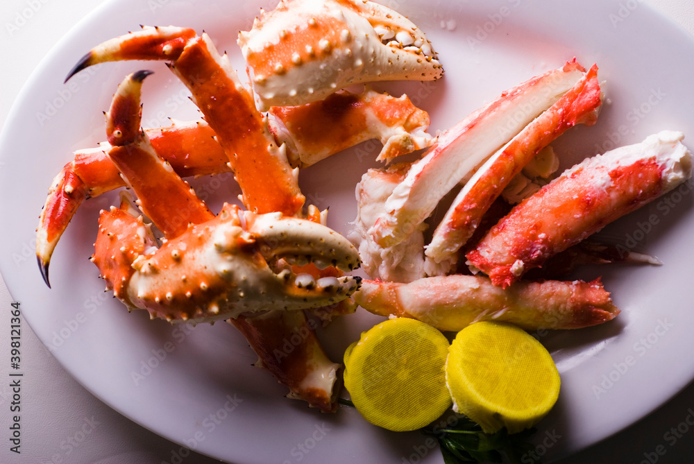King crab or Dungeness legs . Jumbo Crab served with lemons, spicy rémoulade sauce on top of a mixed green salad. Classic American restaurant or steakhouse appetizer or entree. King crab or Dungeness legs . Jumbo Crab served with lemons, spicy rémoulade sauce on top of a mixed green salad. Classic American restaurant or steakhouse appetizer or entree.