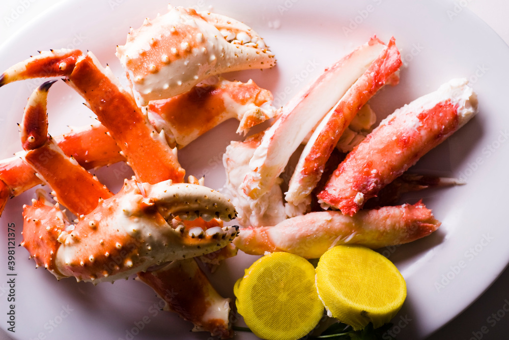 King crab or Dungeness legs . Jumbo Crab served with lemons, spicy rémoulade sauce on top of a mixed green salad. Classic American restaurant or steakhouse appetizer or entree. King crab or Dungeness legs . Jumbo Crab served with lemons, spicy rémoulade sauce on top of a mixed green salad. Classic American restaurant or steakhouse appetizer or entree.