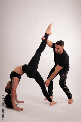 Caucasian teacher and student girl learning exercise flexibility strength acrobatics handstand black sport clothing fitness