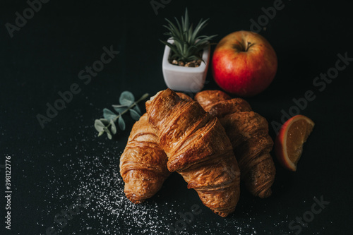 croissant and apple on black