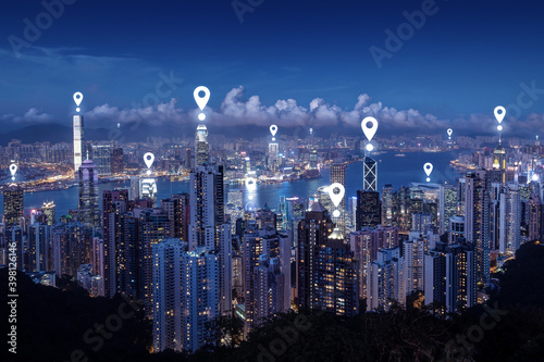 Map pin icons on cityscape of Hong Kong at dusk. Scenic view of Hong Kong's famous skyline from the Victoria Peak at night. Blue tone.