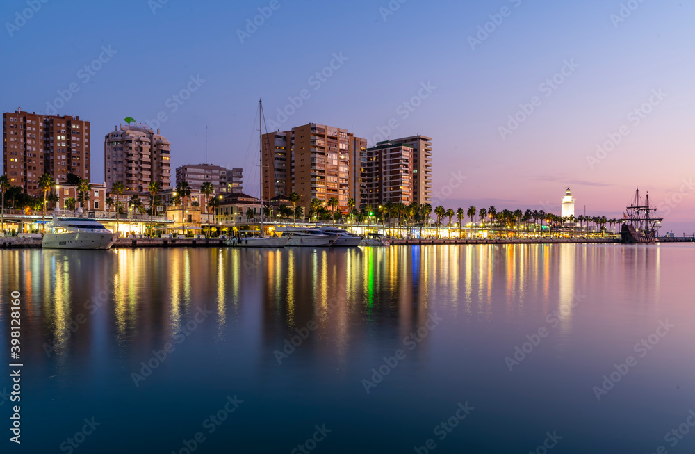 Naklejka premium Yachts parked in Malaga Port with Cityscape and Buildings Behind