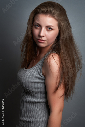 portrait of a beautiful girl with long hair on a gray background