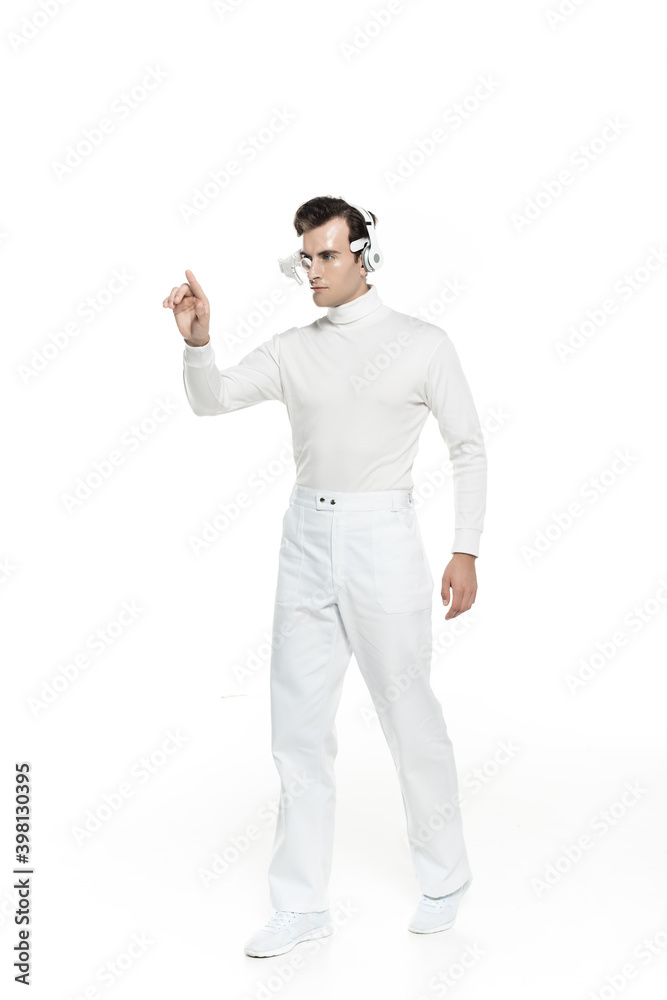 Full length of cyborg in headphones and digital eye lens touching something isolated on white Full length of cyborg in headphones and digital eye lens touching something isolated on white