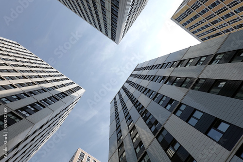 Rounded bottom up perspective view of modern city skyscraper building walls with many windows in business cluster