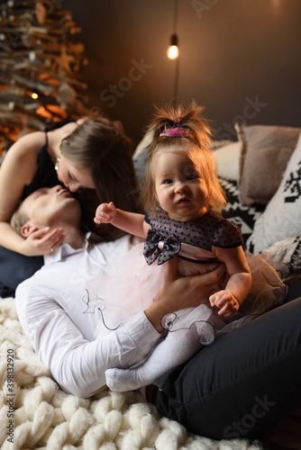 Father mom and their little one year old daughter have fun together before christmas.
