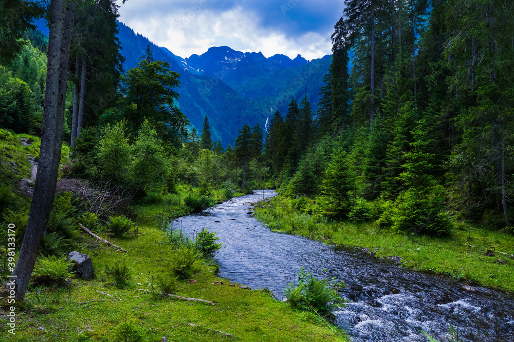 Gebirgsfluss zum steirischen Bodensee in der Steiermark eingebettet in idyllischer grüner Berglandschaft