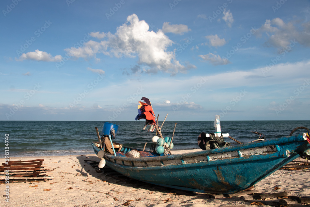 fishing boat on a lonesome beach with white sand and blue water somewhere in Thailand