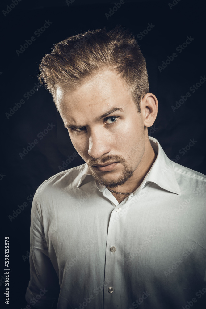 Young man dressed in white shirt studio portrait