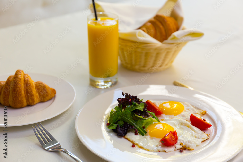 Tasty breakfast with scrambled eggs, juice, croissant and cup of coffe
