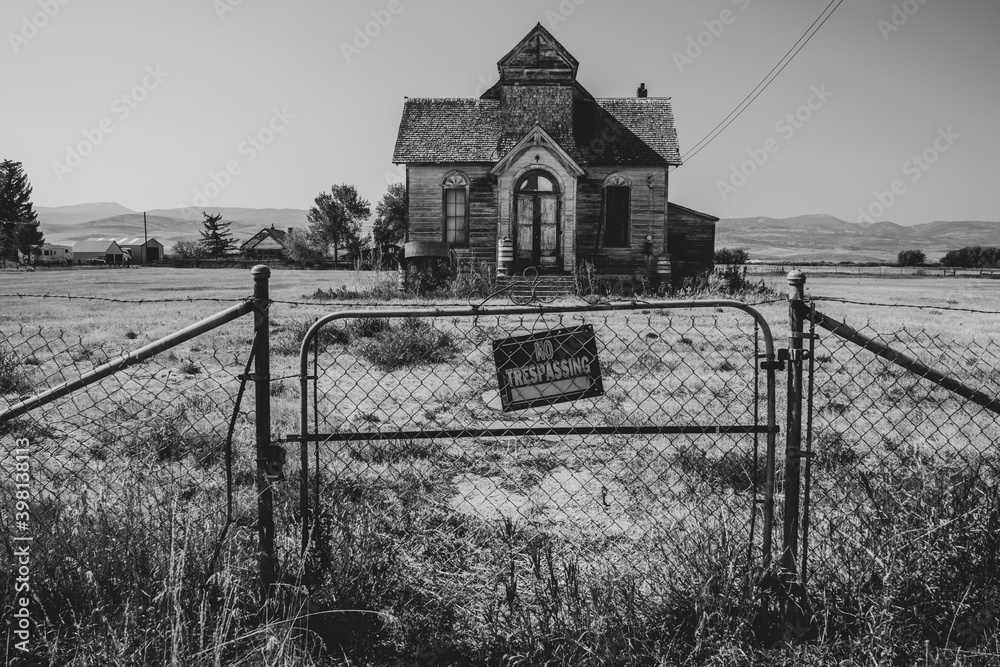 Fototapeta premium Old, abandoned LDS mormon church in Ovid, Idaho. No trespassing sign and fence