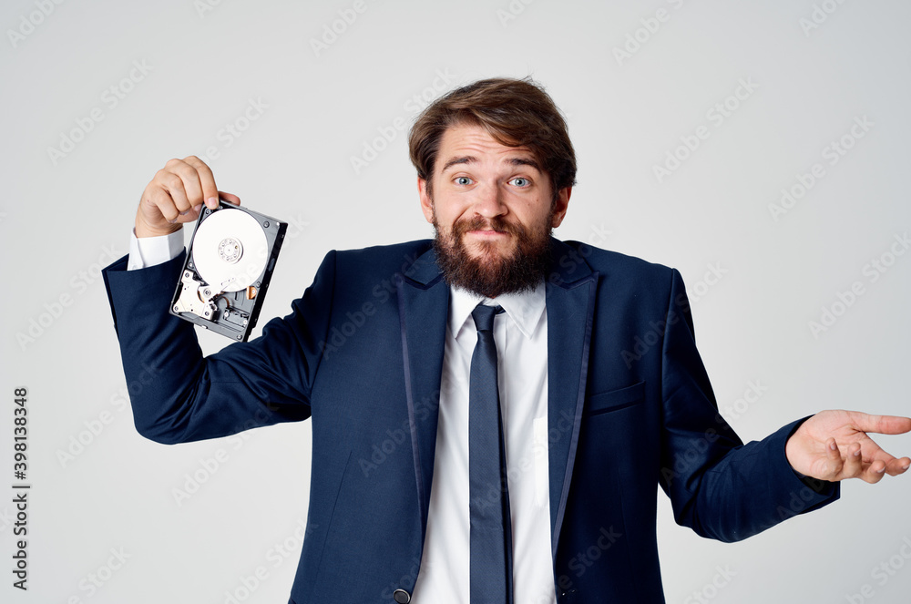 emotional business man in a suit gesturing with his hands and disassembled hard drive emotional business man in a suit gesturing with his hands and disassembled hard drive