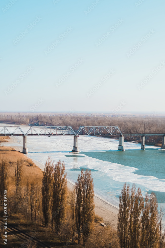 Landscape of railway bridge over a frozen river.