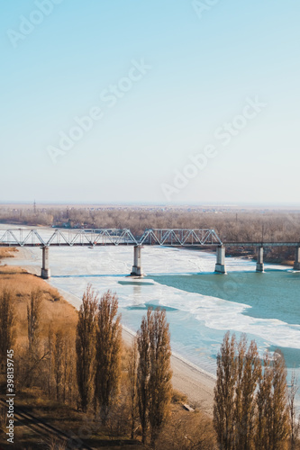 Landscape of railway bridge over a frozen river.