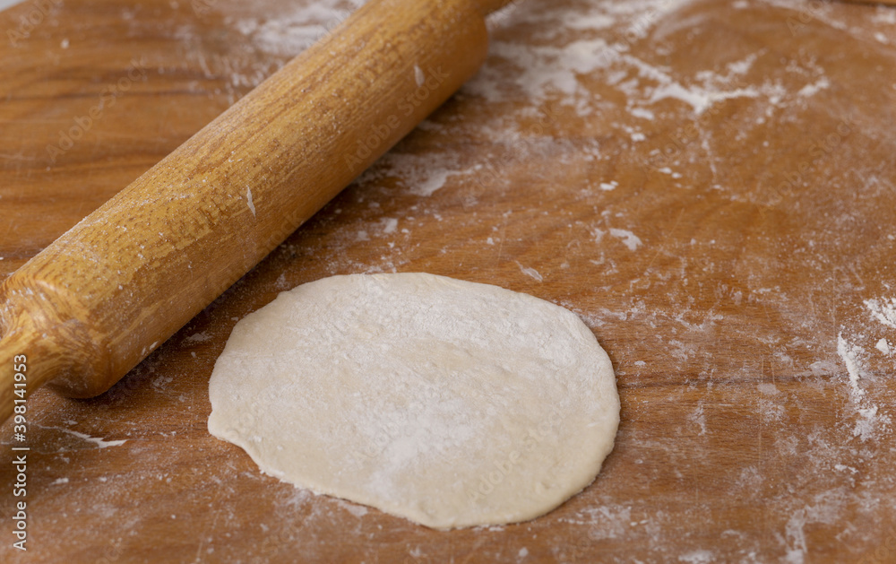 rolling dough and making bread on a roller and wood at home