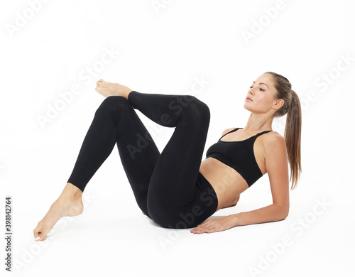 Young sporty woman practicing, doing crisscross exercise, bicycle crunches pose, working out, wearing sportswear.