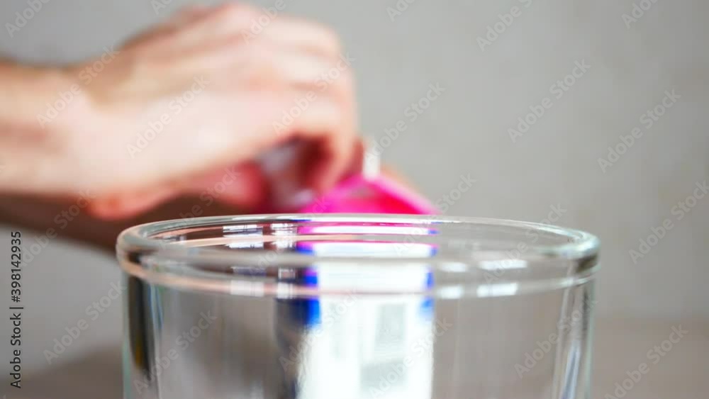 A man opens a milk carton and pours the milk into a glass close-up A man opens a milk carton and pours the milk into a glass close-up