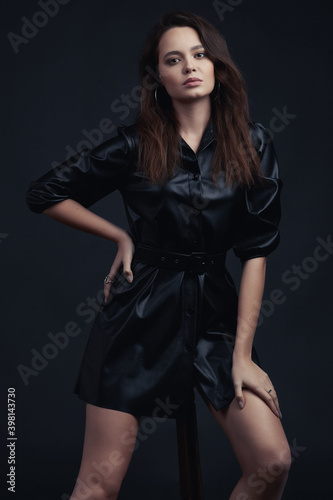 Young brunette girl poses in style clothes