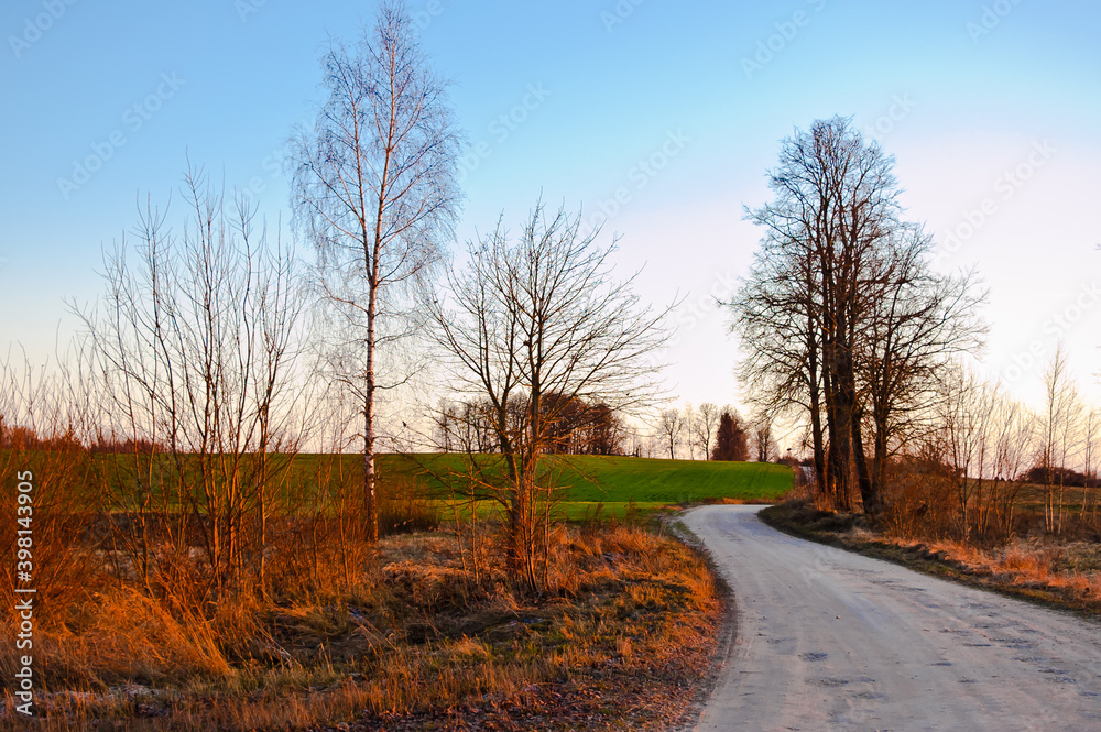 rural landscape, winding road and field in the evening at sunset rural landscape, winding road and field in the evening at sunset