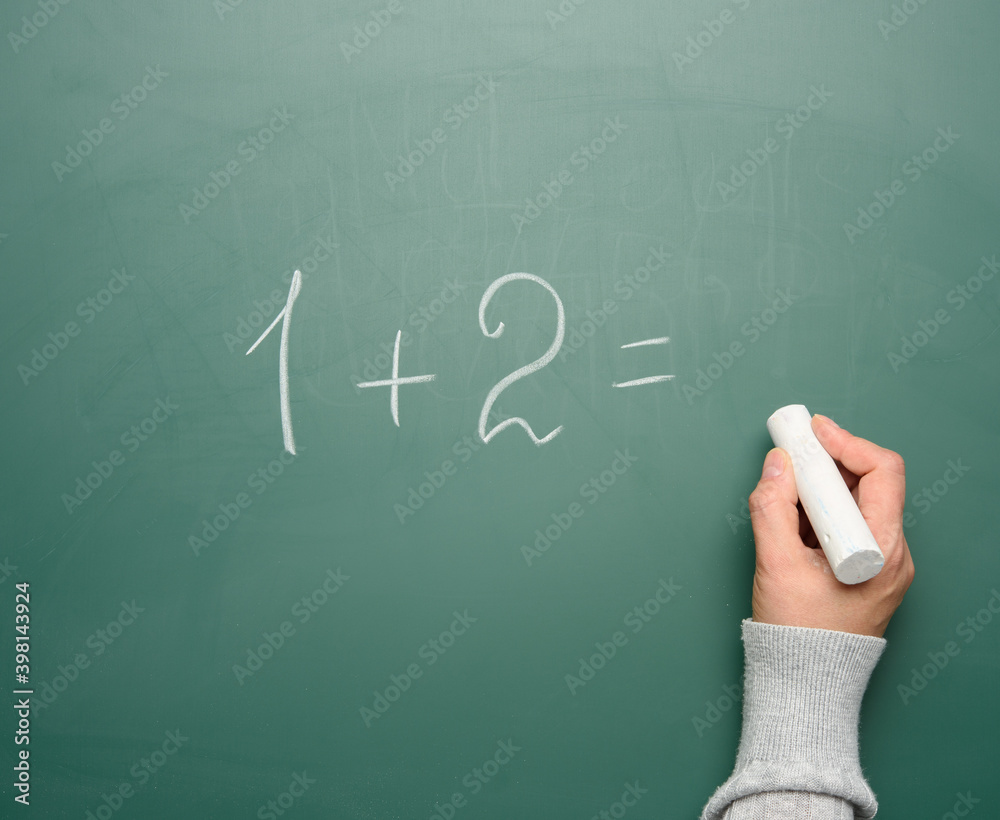 math example written in white chalk on a green chalk board and a woman's hand with white chalk math example written in white chalk on a green chalk board and a woman's hand with white chalk