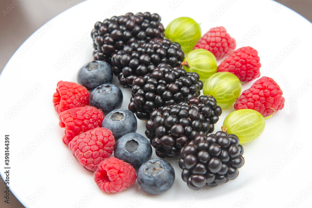 fresh different berries on a white plate. useful vitamin healthy food fruit. healthy vegetable breakfast fresh different berries on a white plate. useful vitamin healthy food fruit. healthy vegetable breakfast