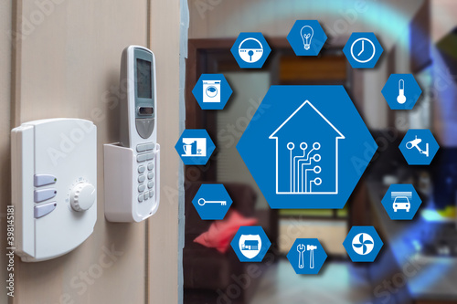 Devices for IOT home control. IOT system icons. Smart home symbols on background of apartment. Remote control is fixed on the wall of the house. Concept - home control using iot technology