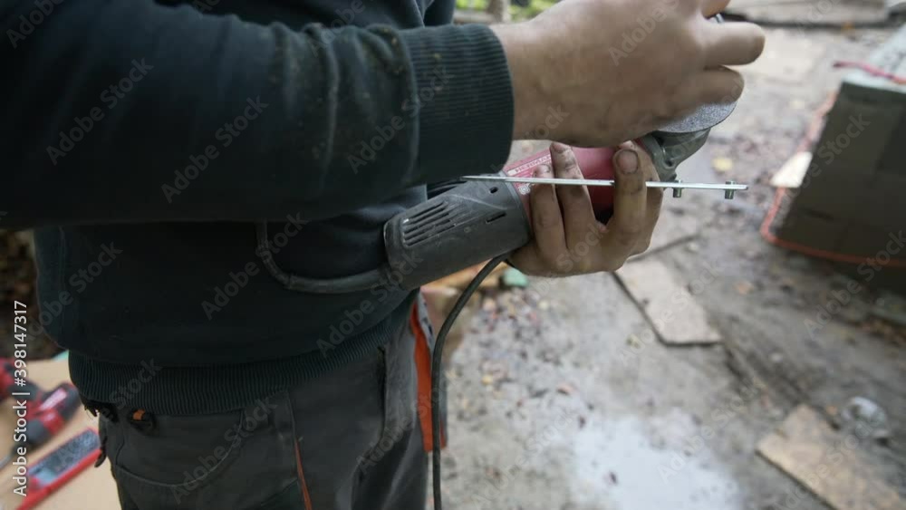 Worker changes grinding wheel on an angle grinder