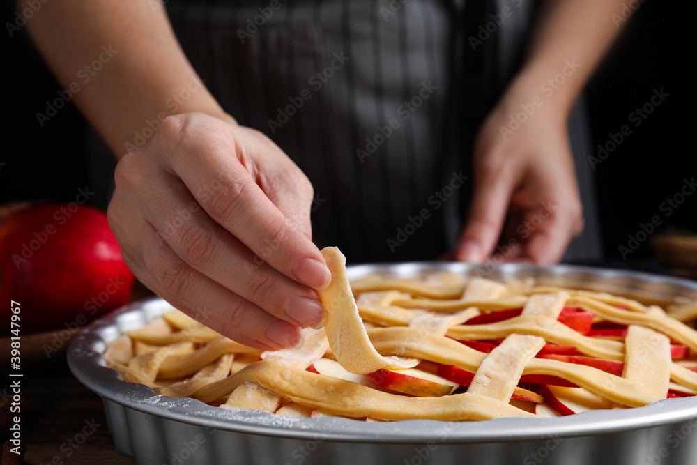 Woman making lattice top for traditional English apple pie, closeup Woman making lattice top for traditional English apple pie, closeup