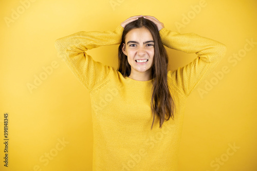 Obraz na plátně Pretty girl wearing a yellow sweater standing over isolated yellow background su