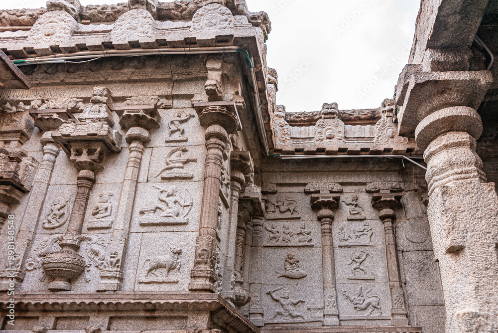 Hampi, Karnataka, India - November 4, 2013: Virupaksha Temple complex. Astrological symbols chiseled in beige brown stone facade at Shiva Sanctum under silver sky.