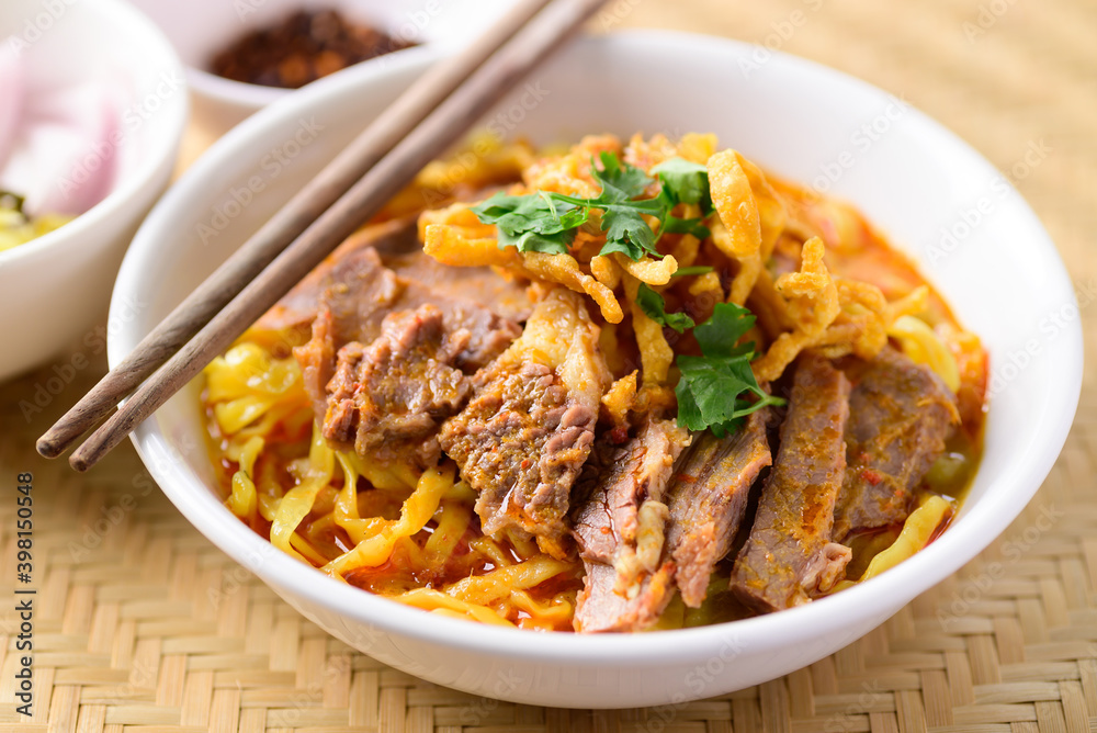 Northern Thai food (Khao Soi), Spicy curry noodles soup with beef eating with pickled mustard, shallot, lime and ground chili fried in oil Northern Thai food (Khao Soi), Spicy curry noodles soup with beef eating with pickled mustard, shallot, lime and ground chili fried in oil