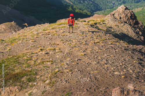 man walking uphill on a mountain terrain