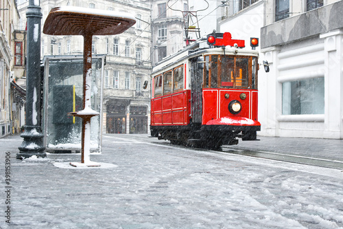 Red nostalgic tram is moving on the Istiklal street in winter day with snow. Istiklal Street is the most popular destination in Beyoglu, Taksim, Istanbul