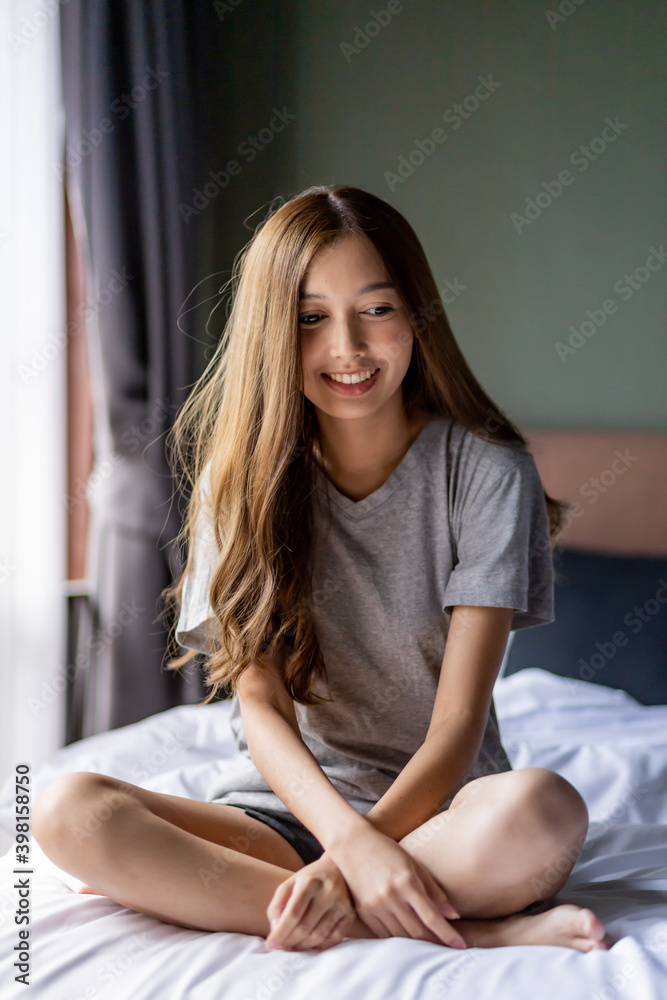 Beautiful long hair women sitting on the bed. 