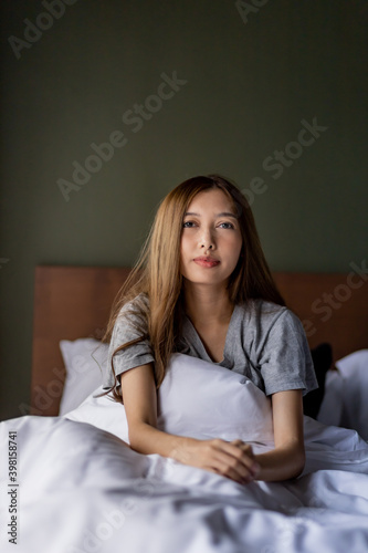 Beautiful long hair women sitting on the bed.  © Rattanachoat