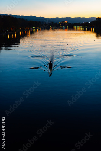 Lonely canoe kayak creating water ripples in calm sunset water canal sport rowing scenic sunset view in Plovdiv, Bulgaria © Valentin
