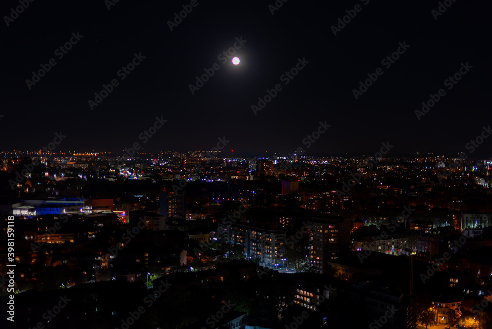 Big dark city lit up by moonlight and thousands of small lights high point view from hill peak of Plovdiv, Bulgaria